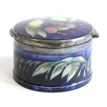 William Moorcroft (British, 1872-1945): A Wisteria Pattern Circular Hinged Trinket Box, with