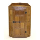 Mouseman: A Robert Thompson Panelled Oak Hanging Corner Cupboard, the single door opening to