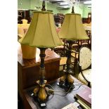 A pair of 20th century black and gold painted table lamps, with green silk shades