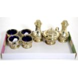 A seven piece silver condiment set with repousse decoration