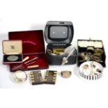 A silver squeeze action tobacco box by Walker & Hall, various silver napkin rings, spoons, two