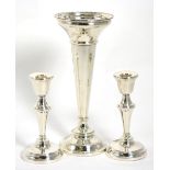 A large silver trumpet shaped vase; and a pair of silver candlesticks