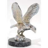 A Chrome on Brass Car Mascot in the form of an Eagle, the wings outstretched, standing on a circular