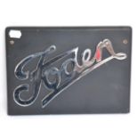 A Chromed Radiator Badge for a Foden Lorry, mounted on an ebonised wooden board with drill holes,