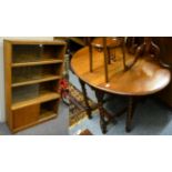 An oak gate leg dining table and a four tier bookcase