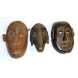 A Carved Wood Mask, possibly Alaskan, as a man with twisted nose and mouth, the reverse set with red