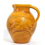 A Susie Cooper Carved Ware jug, incised with fighting gazelles, covered in a matt orange glaze,