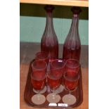 A pair of 19th century cranberry flash glass decanters and a set of seven cranberry wines