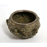 An Indian white metal bowl decorated in relief with figures amongst trees, stamped Bombay