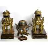 A pair of gilt bronze Buddhistic lions on hardwood stands, a cloisonne censer (a.f.) and a bronze