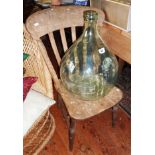 Large glass carboy, with a Victorian kitchen chair