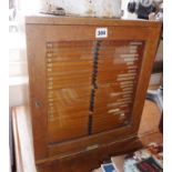 Glazed collector's cabinet with 28 slide-out drawers, by T. Gerard & Co