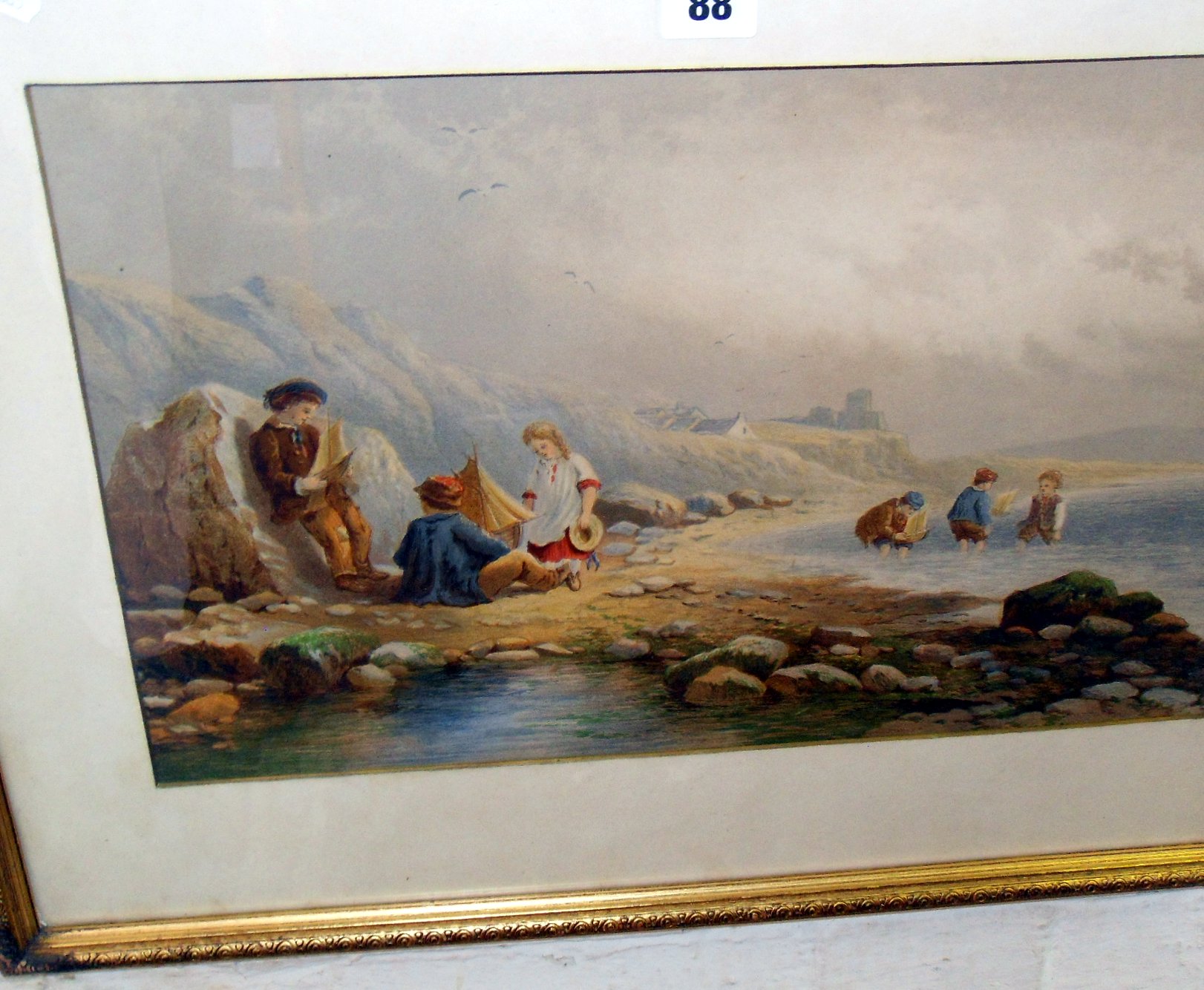 A Victorian chromolithographic of children playing on a beach