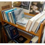 Two shelves of assorted books on Naval ships