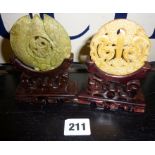 Two Chinese hardstone pendants on carved wooden stands