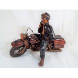 A good quality figurine depicting a gentleman on a motorcycle,