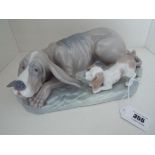 Nao by Lladro - a large figurine depicting a bloodhound, lying down with puppy at his side,