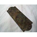 A cast iron finger plate displaying a German emblem