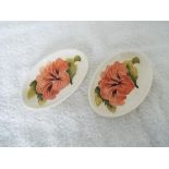 Moorcroft Pottery - a pair of small oval shaped pin dishes decorated with pink coral hibiscus on an