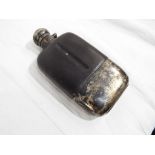 A gentleman's large silver hip flask with part leather body,