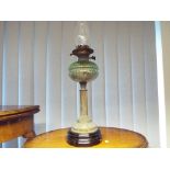 A brass oil lamp with a glass crimped body,