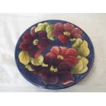 Moorcroft Pottery - a large plate / wall plaque decorated with clematis on a blue ground 25.