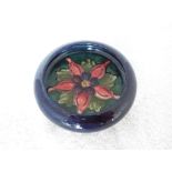Moorcroft Pottery - a small pedestal bowl with inverted rim decorated with columbine on a cobalt