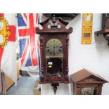 A decorative wood-cased wall clock, the case with opening glazed door, turned decoration,