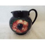 Moorcroft Pottery - a large jug decorated with anemones on a cobalt blue ground,