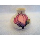 Moorcroft Pottery - a small squat vase decorated with pink magnolia on an ivorine ground, 7.