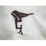 A vintage brass sewing bird clamp