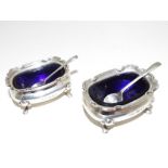 A George V pair of hallmarked silver salts with blue glass liners and hallmarked silver serving