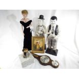 A pair of figurines depicting Laurel and Hardy, a barometer,