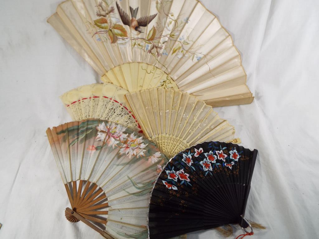 A good collection of lady's fans to include an ivory and bone fan with silk floral decoration,