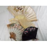 A good collection of lady's fans to include an ivory and bone fan with silk floral decoration,