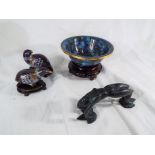 A good quality cloisonne bowl on a carved wooden plinth,