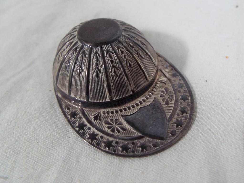 A white metal miniature cap,