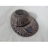 A white metal miniature cap,