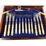 A mahogany cased set of six carved bone-handled fish knives and forks,