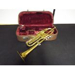 A brass lacquered B flat trumpet by Melody Maker with mouthpiece in original hard case.