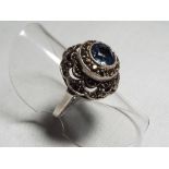 A lady's silver and marcasite ring set with central blue gemstone,