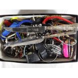 An unsorted box of costume jewellery, in