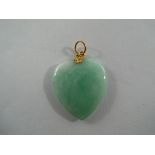 A heart shaped jade pendant with gold to