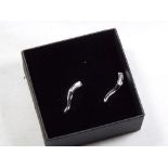 A lady's pair of 9 carat white gold 10 pt diamond set stick earrings,