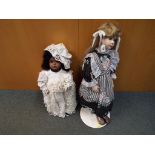 2 dress dolls on stands. One has a bisque head, glass eyes and open mouth and is approx. 55 cm high.