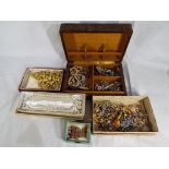 A good quantity of unsorted costume jewellery with leather covered jewellery box