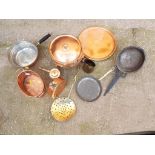 A collection of copper and brass ware to include pans, trays and similar.
