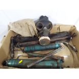 A WWII gas mask (small) marked 1940 with a cloth material bag and a small quantity of grease guns.