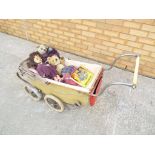 A vintage pram with child's doll and 2 teddy bears and a book entitled "Teddy's Busy Day"