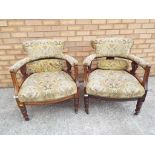 A pair of Victorian upholstered low tub chairs with carved backs.